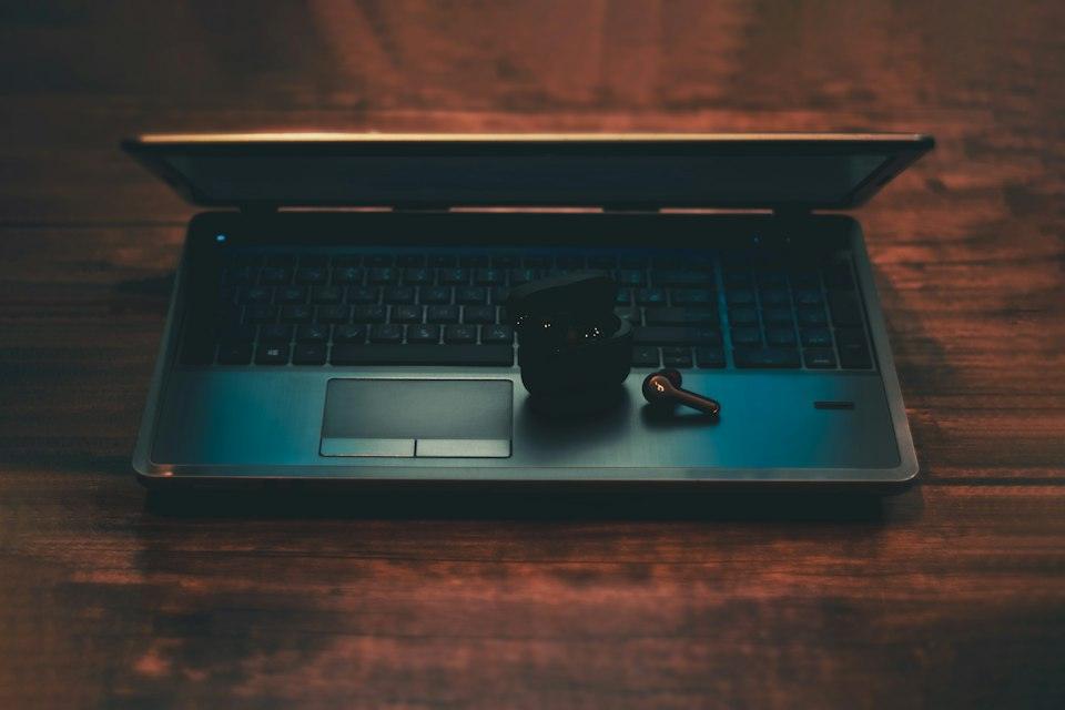 Black and gray laptop computer with black corded mouse on br