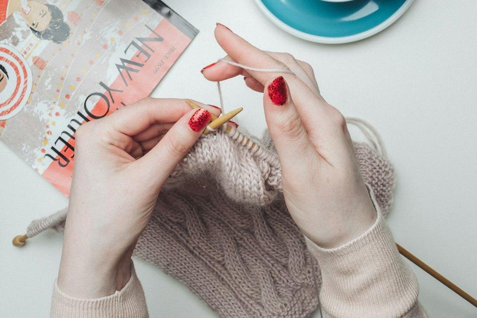 Person knitting beige garment
