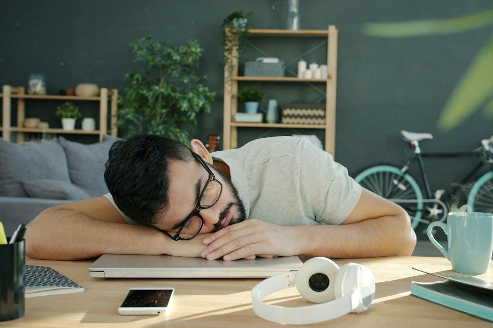 Man sleeping on a laptop at a desk