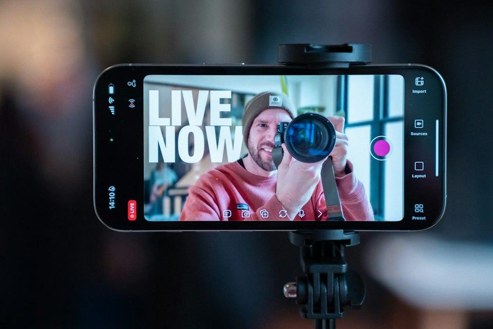 Man filming himself with a smartphone on a tripod