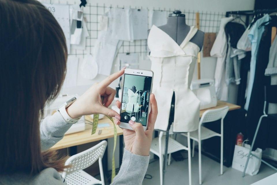 A fashion designer takes a picture of her work