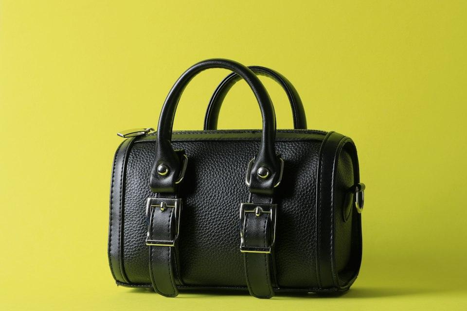 A black leather bag on a yellow background
